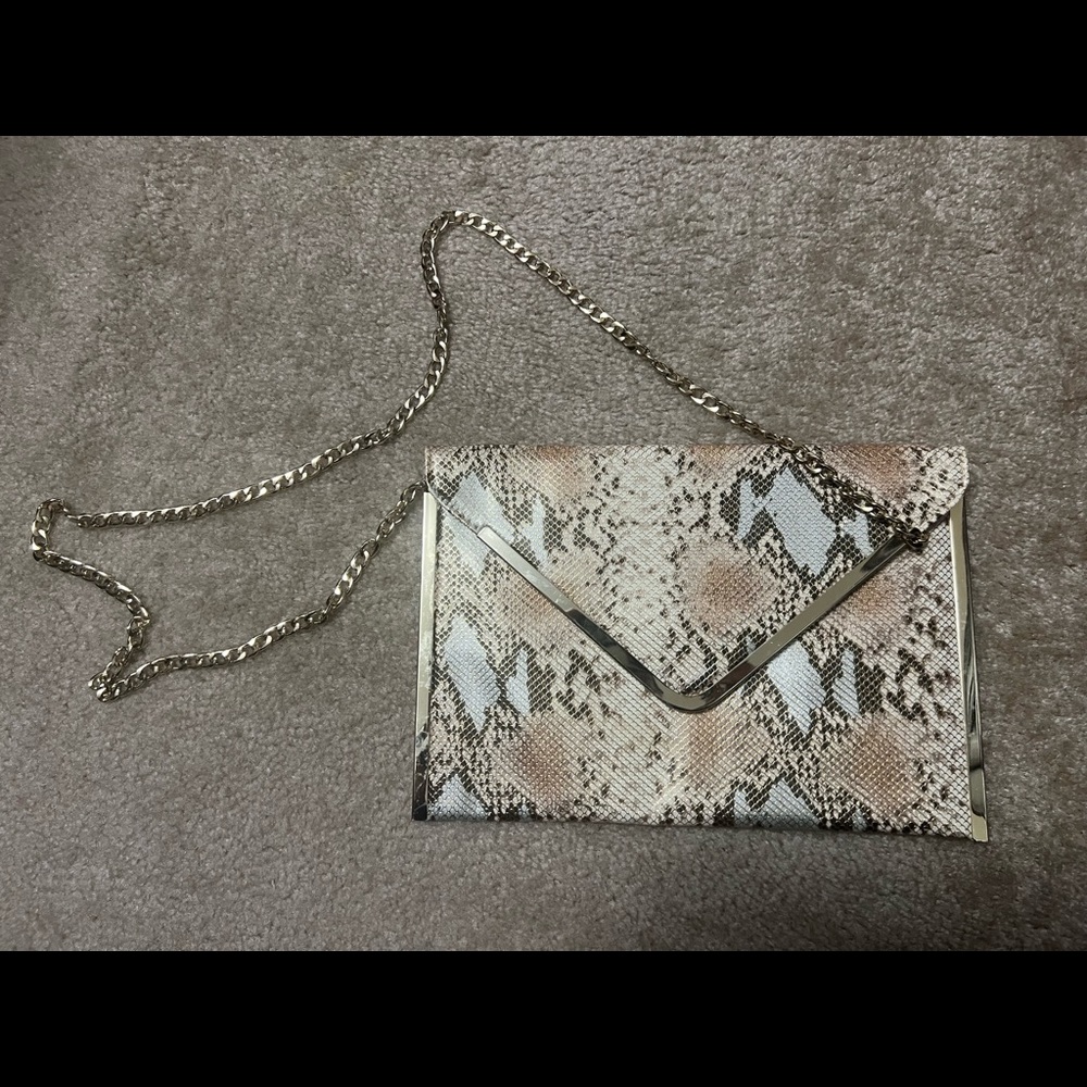 Bebe Large envelope style snakeskin print purse with gold chain. Minimal use